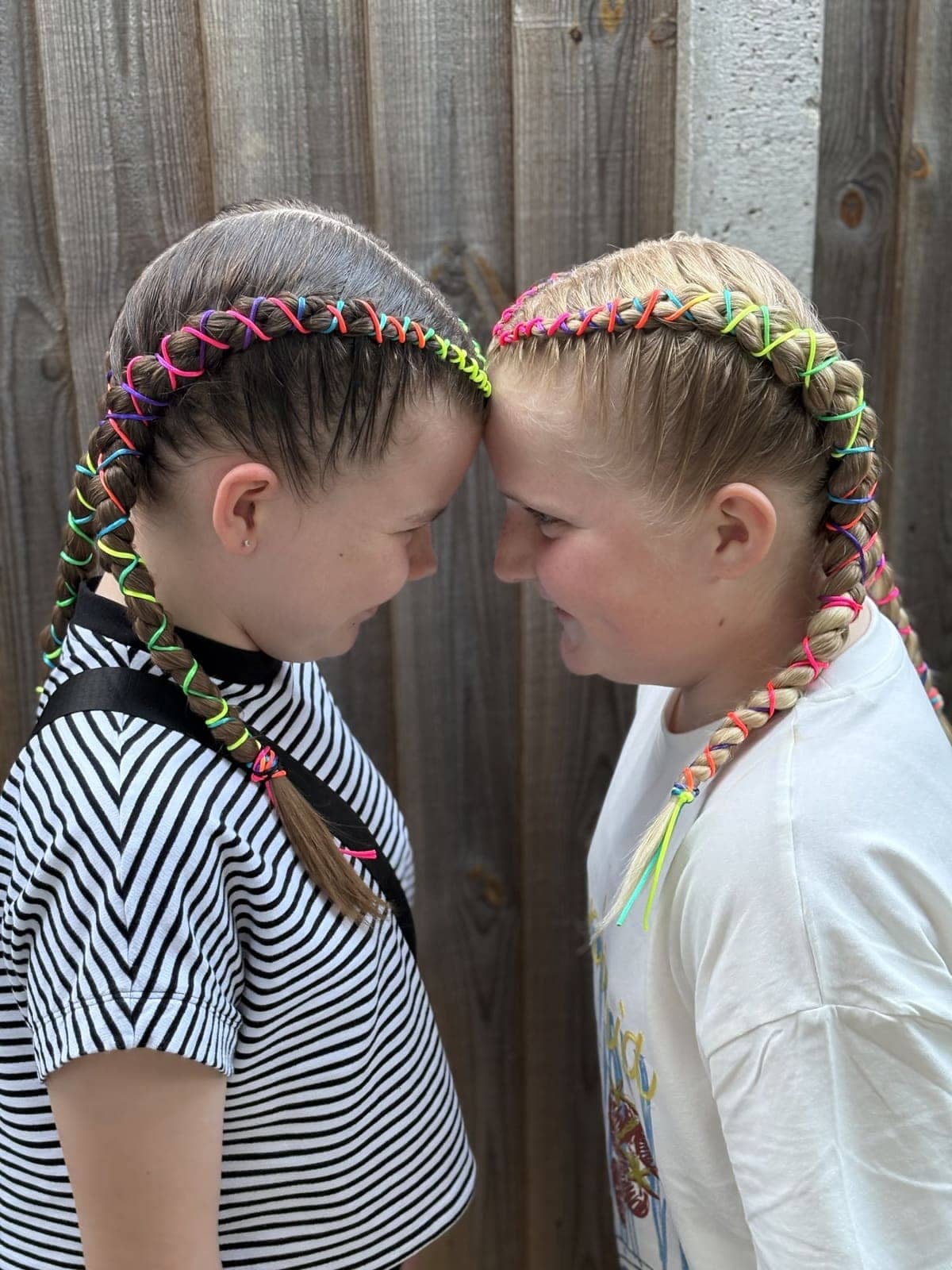 Two girls with rainbow thread braids at Brownie camp